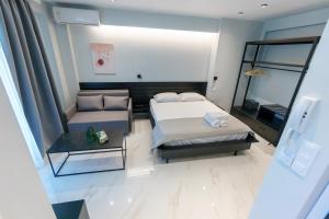 a bedroom with a bed and a couch and a table at Lighthouse Apartments in Kriopigi