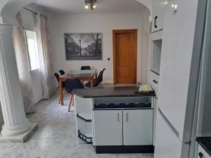 - une cuisine et une salle à manger avec une table et un comptoir dans l'établissement Villa Noelia Benalmadena, à Benalmádena