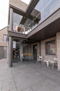a building with a patio with chairs in front of it at Logies Ternier in Nieuwpoort