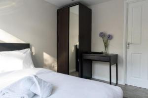 a bedroom with a bed and a table with a mirror at Immaculate 4-Bed House in Southampton in Southampton