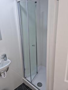 a shower with a glass door next to a sink at Immaculate 4-Bed House in Southampton in Southampton
