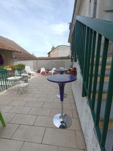 una mesa púrpura en un patio con balcón en HOTEL DE FRANCE, en La Tour-du-Pin
