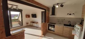 een keuken met een groot raam en een wastafel bij Le grenier de Véro in Houssen