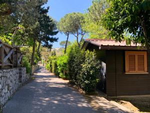 a road next to a building and a stone wall at Village Camping Santa Fortunata - Campogaio in Sorrento