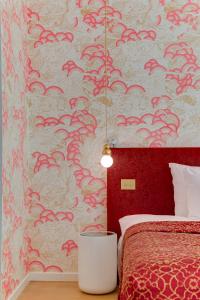 a bedroom with a bed and a red wall at Small Luxury Hotel De Witte Lelie in Antwerp