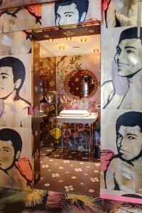 Small Luxury Hotel De Witte Lelie في أنتويرب: حمام مع مرآة مع لوحة على الحائط