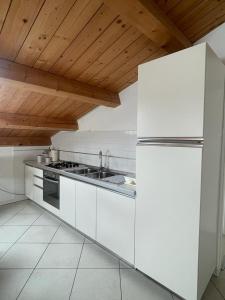 Il comprend une cuisine avec des appareils blancs et un plafond en bois. dans l'établissement VILLA EMMA -WALTERIGATO Apartments SOLO PER FAMIGLIE, à Lido di Jesolo