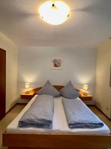 a bedroom with a large bed with two pillows at Winzerhaus im Oberdorf - FeWo u Zimmer - auch kombinierbar in Erden