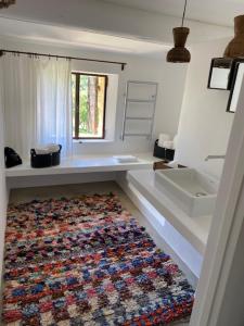 een badkamer met een tapijt op de vloer en een wastafel bij Le Domaine du Castellas in Sivergues
