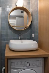 ein Badezimmer mit einem Waschbecken und einem Spiegel über einer Waschmaschine in der Unterkunft Charming love nest near Montmartre in Paris