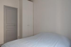 ein Schlafzimmer mit einem weißen Bett und einem Schrank in der Unterkunft Charming love nest near Montmartre in Paris