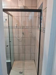 um chuveiro com uma porta de vidro na casa de banho em suite Perto do aeroporto de guarulhosAv Jovita 401 em Guarulhos