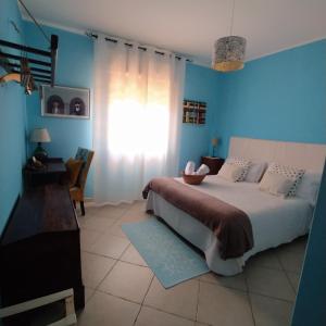 a bedroom with a large bed with blue walls at Il Sentiero B&Bìo in SantʼAntìoco