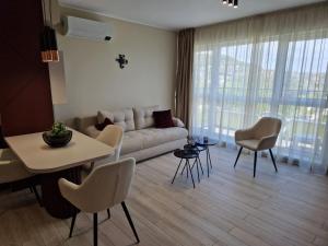 uma sala de estar com um sofá, uma mesa e cadeiras em PAPAYA APARTMENTS em Varna