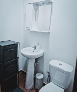 y baño con lavabo, aseo y espejo. en Apartment Golden - 2BR with Parking, Prime Location, en Pristina