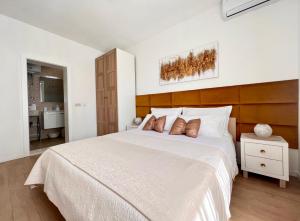 a bedroom with a large white bed with a wooden headboard at Apartments Pera in Hvar
