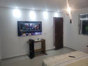 um quarto com uma televisão de ecrã plano na parede em suite Perto do aeroporto de guarulhosAv Jovita 401 em Guarulhos