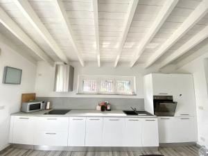 a kitchen with white cabinets and a coffered ceiling at VILLA GIOIA - Piscina nel Monferrato in Pecetto di Valenza