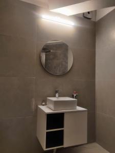 łazienka z umywalką i lustrem na ścianie w obiekcie The White House w mieście Nainital