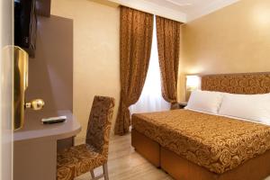 una camera d'albergo con letto e sedia di Hotel Fellini a Roma