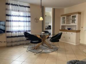 a kitchen with a dining room table and chairs at Lindenhof WE 5 in Dahme