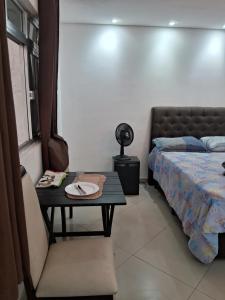 a room with a table with a bed and a table with a plate at Kitnet Suite próxima aeroportoe Guarulhos in Guarulhos