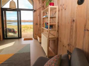 Pokój z drewnianą ścianą z półką na książki w obiekcie North Light Studio w mieście Carinish