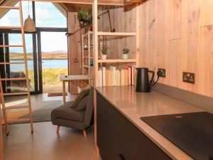 a kitchen with a counter and a chair in a room at North Light Studio in Carinish