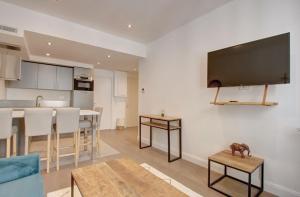 een keuken en een woonkamer met een flatscreen-tv aan de muur bij JEJ1-Two bedrooms Cannes Center in Cannes