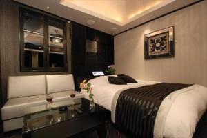 1 dormitorio con cama, mesa y sofá en HOTEL Shuffle, en Tokio