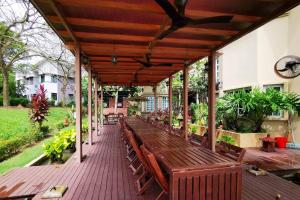 een terras met houten banken in een huis bij Tiara Golf Villa With Pool in Melaka