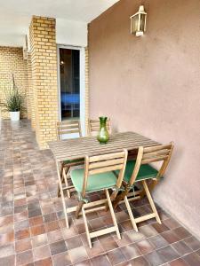 a wooden table and chairs on a patio at Gavà Beach Apartment in Gavà