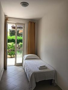 a bedroom with a bed and a sliding glass door at Appartamento a Forte dei Marmi con giardino e 2 posti auto in Querceta