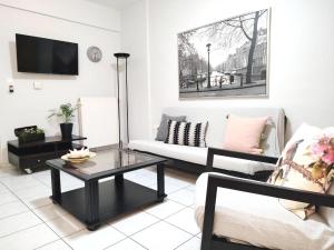 uma sala de estar com um sofá e uma mesa de centro em Palmeira Studio em Preveza