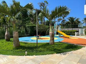 ein Spielplatz mit Palmen und einer Rutsche in der Unterkunft Vista maravilhosa na Riviera in Riviera de São Lourenço