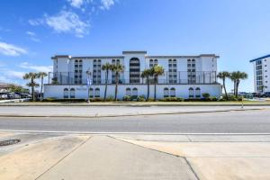 a white building with palm trees in front of a street at Relax'n'Retreat @ BellaView603 in Daytona Beach