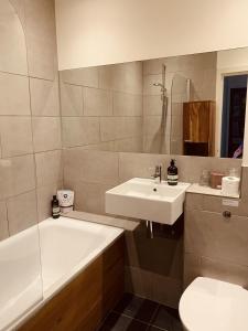 uma casa de banho com um lavatório, uma banheira e um WC. em Your Private Hoxton Apartment Sleeps 3 London Zone 1 em Londres