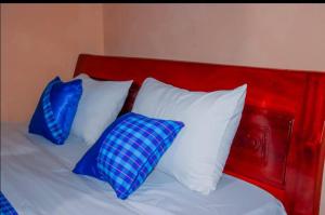 Jambo Afrika Resort في Emali: اثنين من الوسائد الزرقاء جالسين على رأس سرير