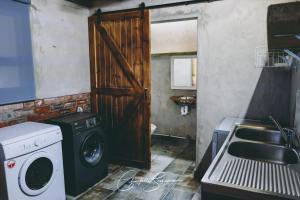 a laundry room with a washing machine and a sink at Oppi Plaas See Uitsig Seemeeu in Great Brak River