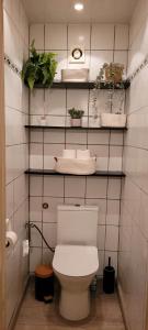 a bathroom with a toilet and shelves with plants at 400m de la mer, calme, lumineux, parking privatif, 3 chambres max 6 personnes in Koksijde