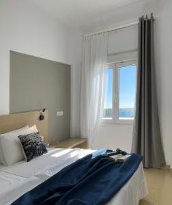 a bedroom with a bed and a large window at Vista Mare in Koutsourás
