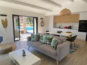 sala de estar con sofá y mesa en Magnifique villa avec piscine au coeur des vignes en Cogolin