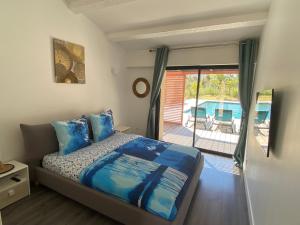 1 dormitorio con 1 cama y balcón con piscina en Magnifique villa avec piscine au coeur des vignes en Cogolin