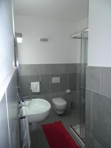 a bathroom with a toilet and a sink and a shower at Residence L'Ancora in Posada