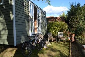 a bike parked next to a house at The Nutbourne Hut - shepherd's hut - pint-sized luxury in Hambrook
