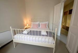 - Cuna blanca con almohadas rosas en la habitación en Elia downtown eco house en Mitilene