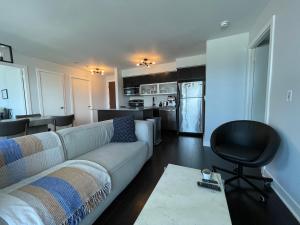 a living room with a couch and a kitchen at TORONTO SKYLINE VIEW CONDO LIBERTY VILLAGE (Private Room & Bath) in Toronto