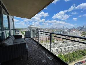 een balkon met een bank en uitzicht op de stad bij TORONTO SKYLINE VIEW CONDO LIBERTY VILLAGE (Private Room & Bath) in Toronto