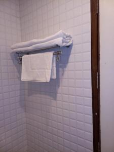 baño con toallas blancas colgadas en un estante en HOTEL BLUE ORCHID - A 3 STAR HEAVEN IN Tricity, en Zirakpur