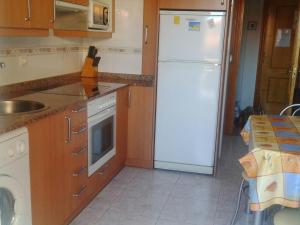 a kitchen with a white refrigerator and a sink at Apartamento en Isla Playa in Isla